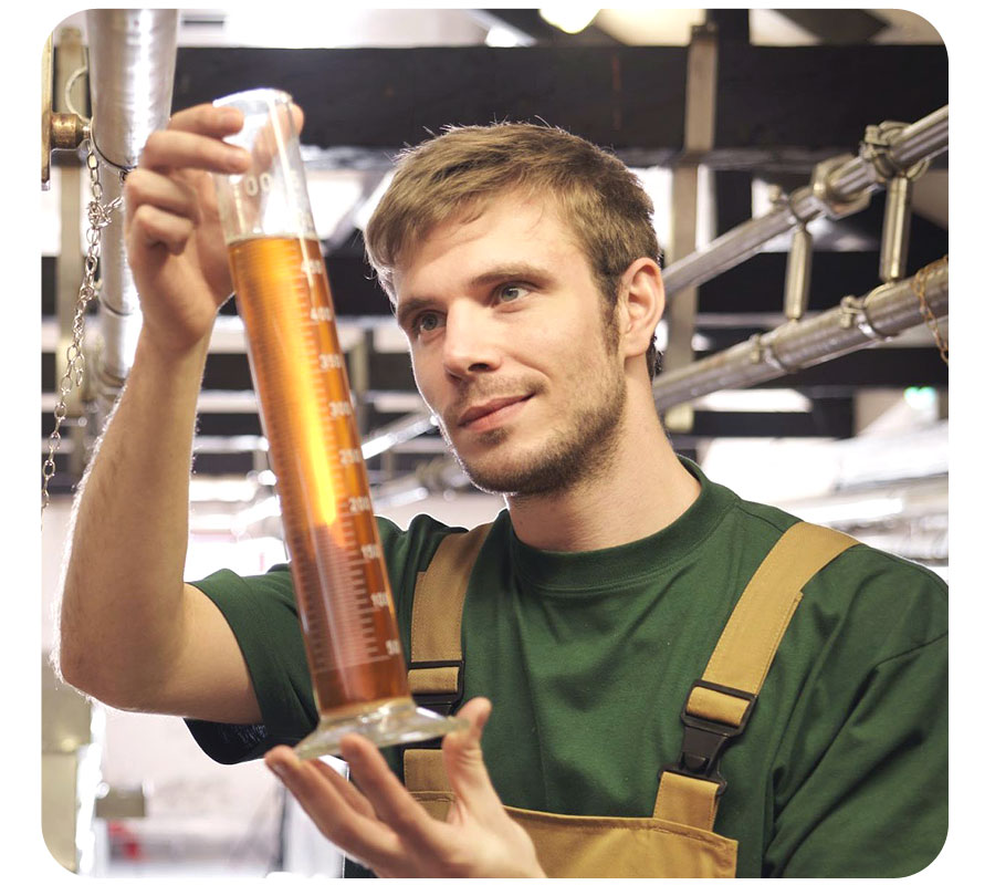 Mestre cervejeiro analisando uma amostra de chopp em um recipiente apropriado